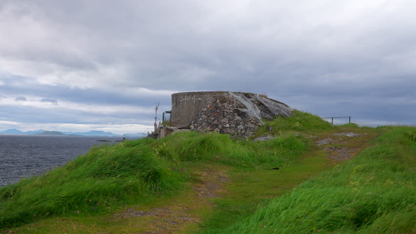 Man Walking Towards The Skrolsvik Fort on Senjehesten In Troms, Norway. - wide shot