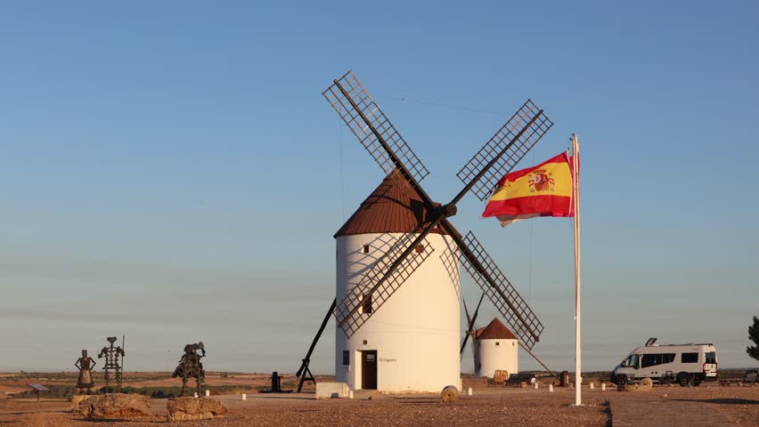 Spanish windmill with the flag of Spain and Don Quixote sculptures