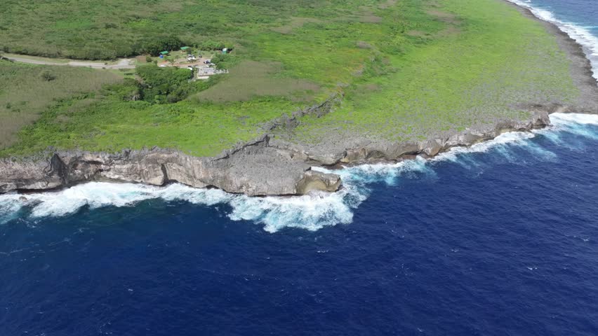 Witness the powerful convergence of history and nature. This dramatic drone footage captures the rugged northern coastline of Saipan, featuring the towering Banzai Cliff and Suicide Cliff. The deep bl