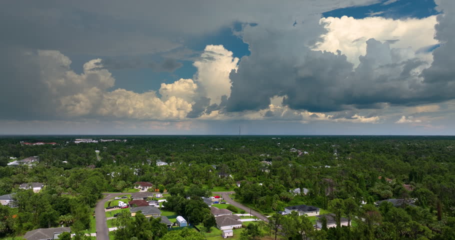 Dark stormy sky over Florida suburbs with heavy rainfall during summer thunderstorm. Tropical rain shower in humid climate.