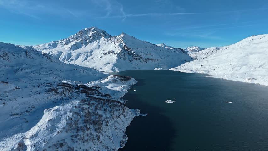 Serene snow-capped mountains and tranquil lake in wintertime daylight