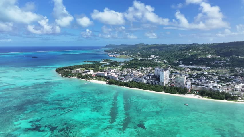 Discover the gateway to the Northern Mariana Islands. This high-quality aerial view showcases the beautiful west coast of Saipan, featuring the iconic skyline of Garapan’s luxury hotels and the expans
