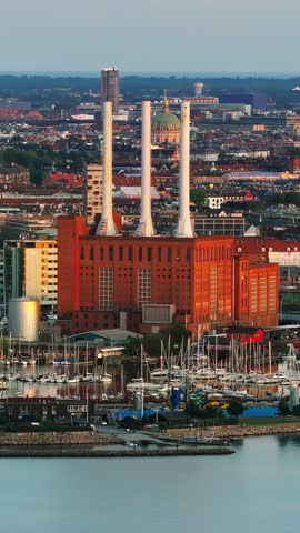 Industrial city panorama with brick power plant and white smokestacks overlooking Copenhagen harbor and city skyline in Denmark