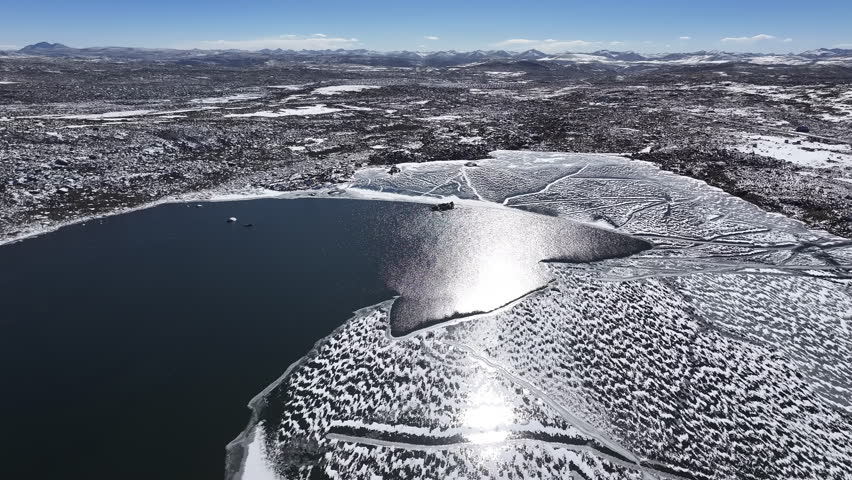 A partially frozen lake in a high-altitude arid landscape