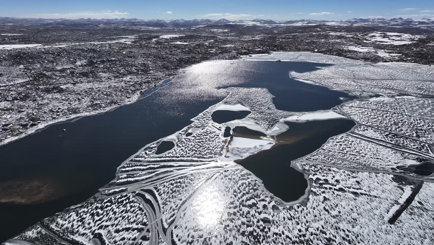 A partially frozen lake in a high-altitude arid landscape