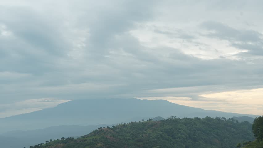Cloudy mountain peak timelapse sky movement over Mount Ciremai. Dramatic overcast weather above volcano landscape in Indonesia.