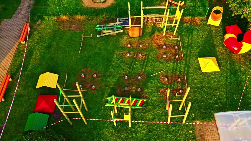 Aerial view of a new playground construction process with safety tape, foundations, and equipment