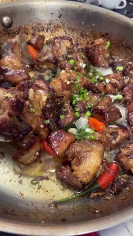 Pork ribs simmering in pan during traditional Vietnamese street food preparation, capturing authentic local cooking, daily life, and food culture in Vietnam.