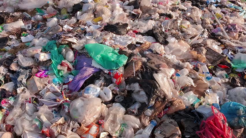 massive landfill filled with plastic waste and garbage, showing severe pollution from above, highlighting environmental crisis, overconsumption, sustainability problems, and human impact on nature