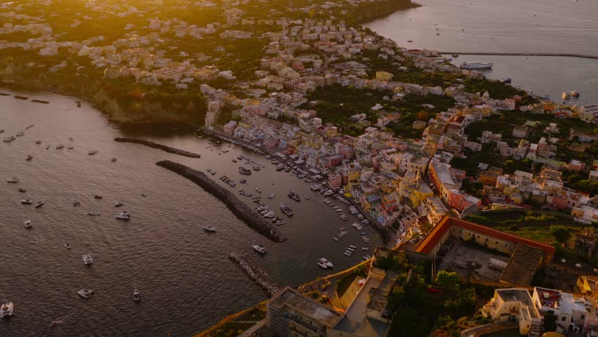 Corricella Port On Procida Island With Colorful Houses At Sunset In Phlegraean Islands, Naples, Italy. - aerial shot