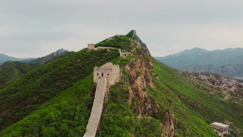 Golden long sunlight illuminates the Great Wall of China near Beijing, an ancient stone monument stretching across rugged mountain ridges, 24 October 2025. Dramatic light and shadow reveal a peaceful historic landscape, ideal for commercial stock footage.