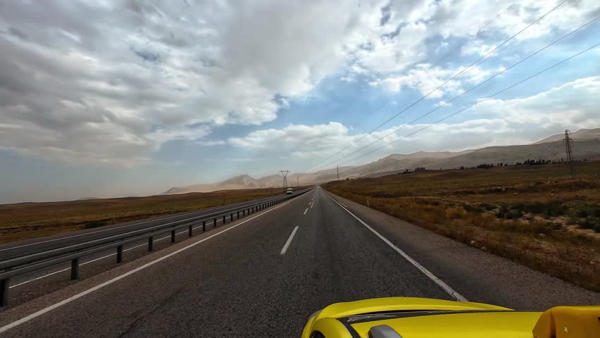 Scenic Highway Road Through Mountains Under Dramatic Cloudy Sky