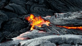 Molten lava flows and cools over dark volcanic rock, creating textured abstract patterns in Hawaii Volcanoes National Park on Big Island at Kilauea Volcano, Hawaii, USA. nature background - Powered by Shutterstock - Get 15% off with code: PIKWIZARD15