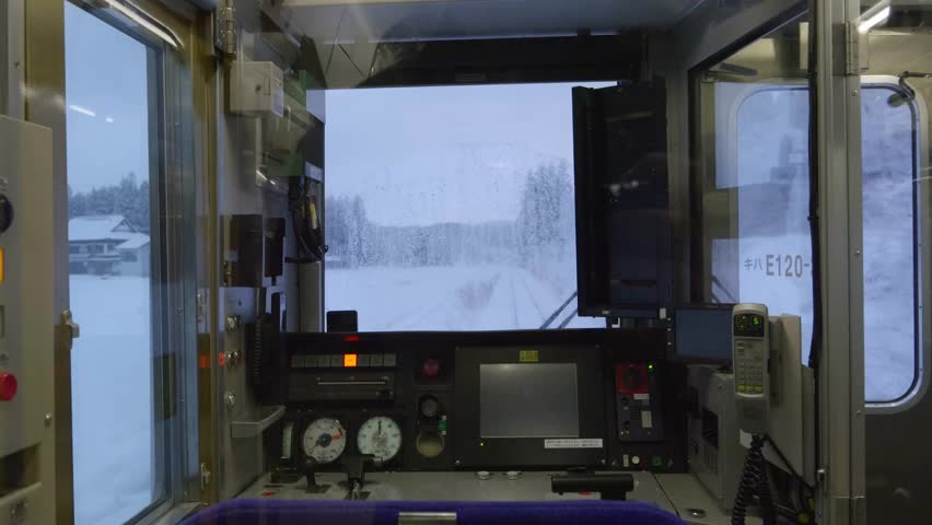 View out of back of driving train through snow landscape