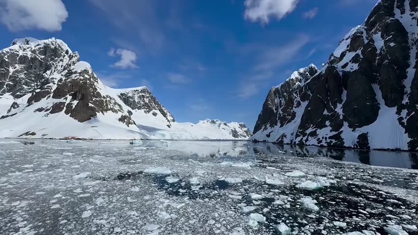 Calm Polar Sea with Ice Floes and Snowy Mountains