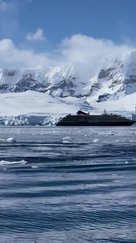 Expedition Ship Cruising Through Antarctic Ice and Mountains