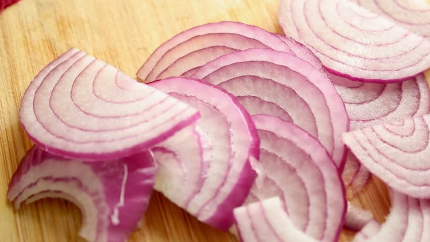Close up of chopped red onion on wooden cutting board 