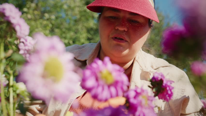A Dedicated Gardener Enjoying the Beauty of Purple Flowers in a Lush Garden, Surrounded by Nature