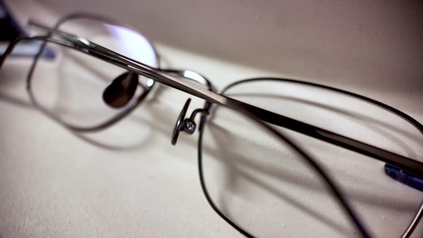 Close Up Of Metal Frame Reading Glasses On A Neutral Surface For Vision Correction And Eye Health Related Concepts And Lifestyle Content Macro Shot.