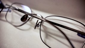 Close Up Of Metal Frame Reading Glasses On A Neutral Surface For Vision Correction And Eye Health Related Concepts And Lifestyle Content Macro Shot. - Powered by Shutterstock - Get 15% off with code: PIKWIZARD15