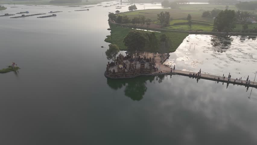 Aerial view of a lake with a temple and a long bridge
