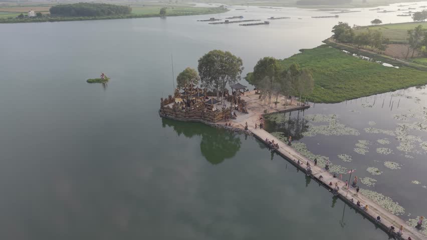 Aerial view of a wooden temple and island bridge on a vast lake