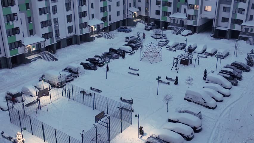 Snowfall in the city. Residential complex and large yard on a winter day