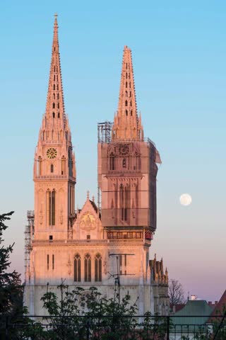 Vertical video time lapse of full moon rising behind cathedral in Zagreb, Croatia