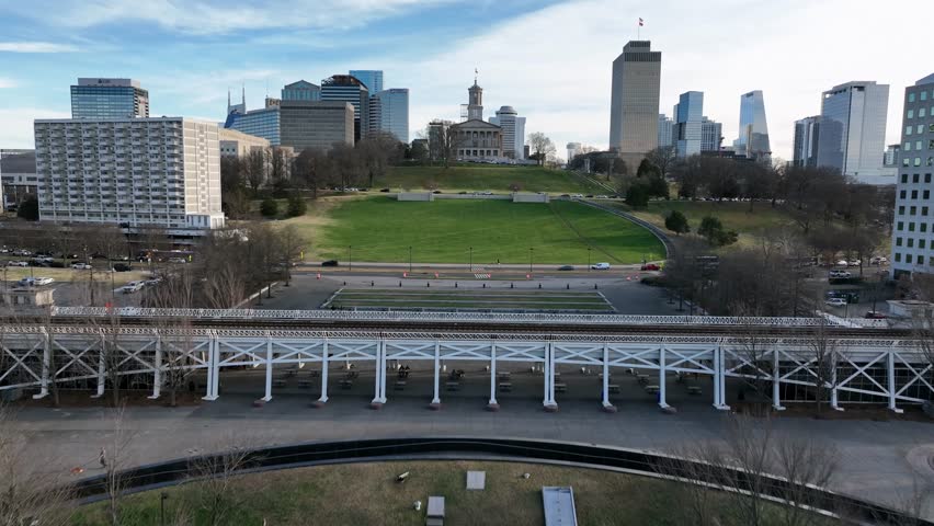 Aerial view of downtown Nashville with green park space, city skyline and historic buildings, showing urban life in United States. Clear day with traffic and modern architecture in USA. Wide shot.