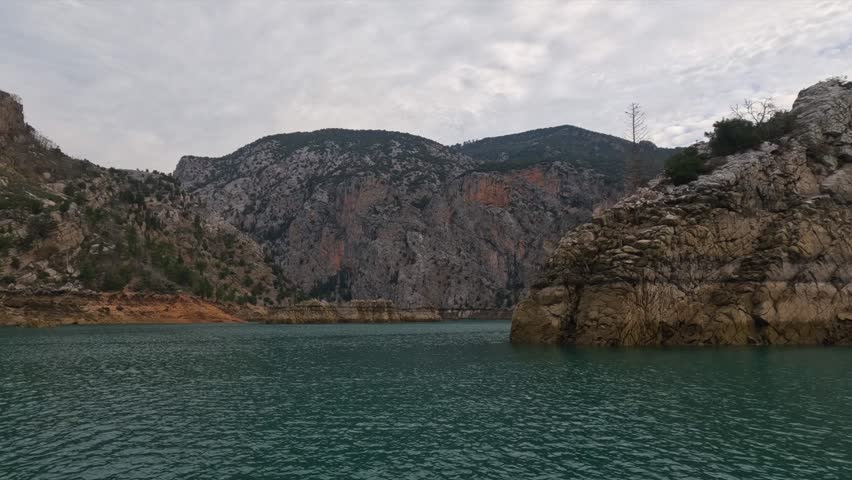 Cruising Across Oymapinar Lake Surrounded by Mountains