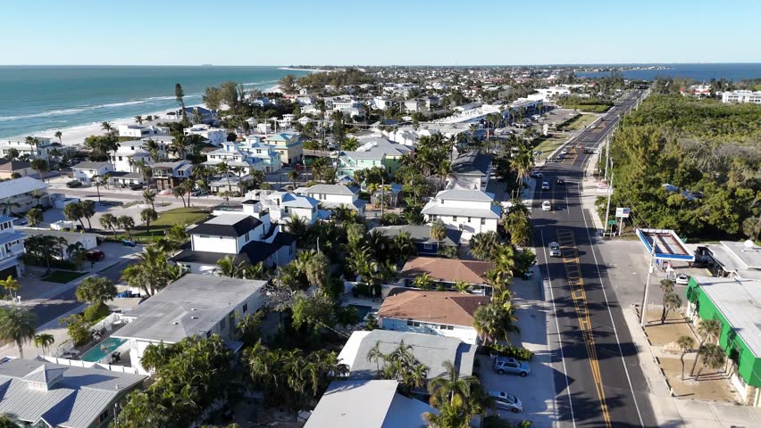 sliding sideways aerial from inside the island to the beach an high waves water on Holmes, Bradenton Florida beach area