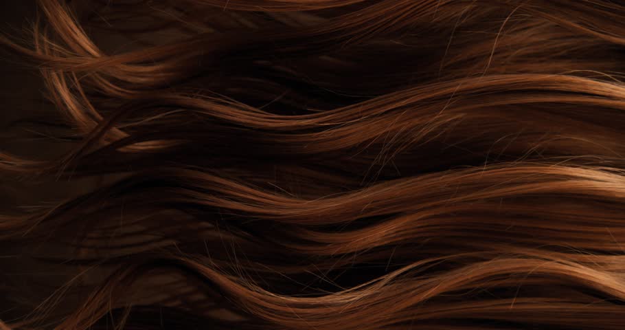 Ultra slow motion shot of dark brown hair flowing in smooth, elegant waves, forming natural curves and motion. Captured at 1000 fps, revealing fine texture, shine, and fluid cinematic movement.