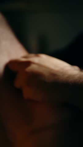 A close-up of a hand gently massaging a bare shoulder in soft, low light, capturing tactile pressure, soothing motion, and intimacy of therapeutic touch easing muscle tension