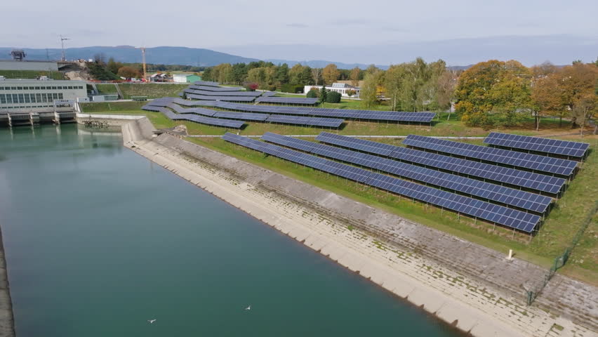 Aerial view of a hydroelectric plant with solar panels, showcasing advancements in renewable energy and sustainability.