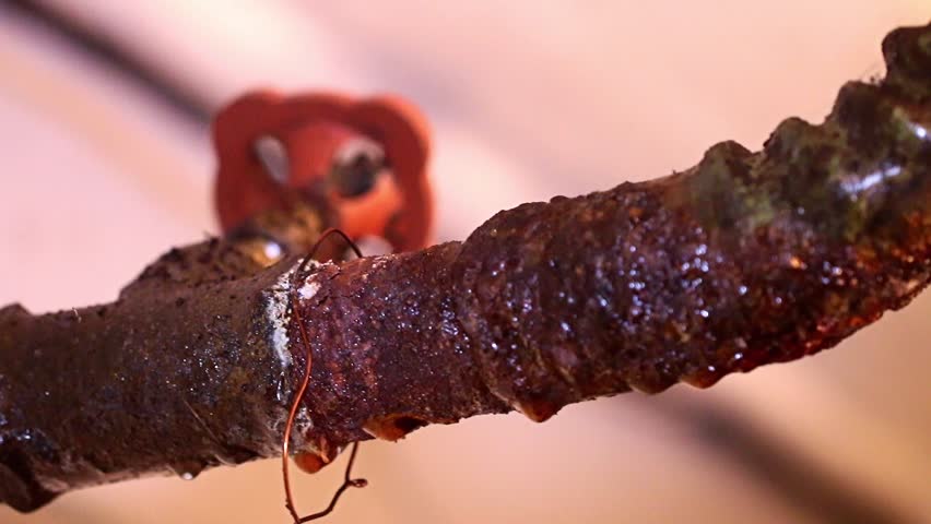 a terrible rusty water pipe in the communal interchange of an apartment building