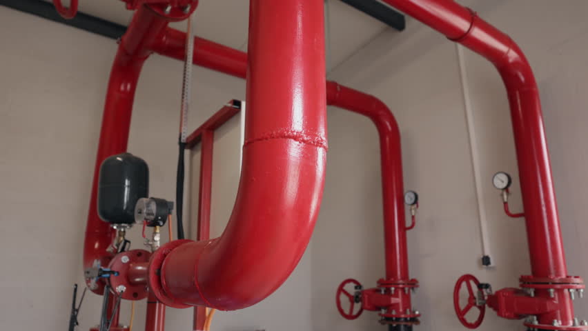 Fire suppression, Control valve, Riser room. Large red industrial pipeline system with visible gauges, valves, and expansion tank, likely part fire suppression network.