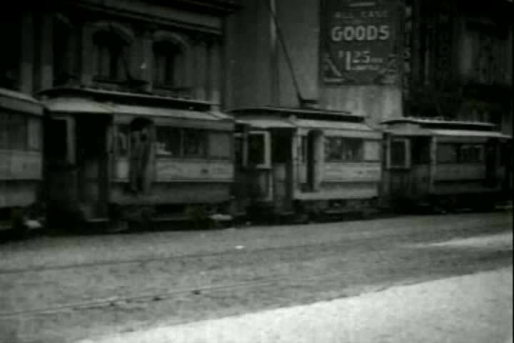 1900s - Trolleys traverse a city street in 1903.