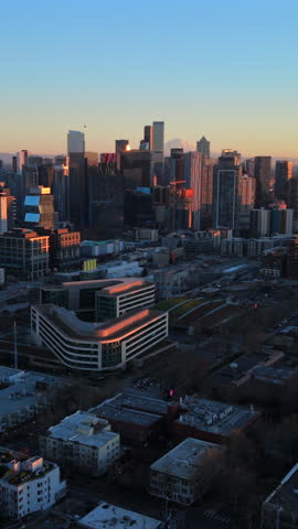 Aerial panorama of Seattle Washington skyline with Space Needle and dense downtown buildings at sunset showing urban growth, modern architecture and warm evening light gently raw.