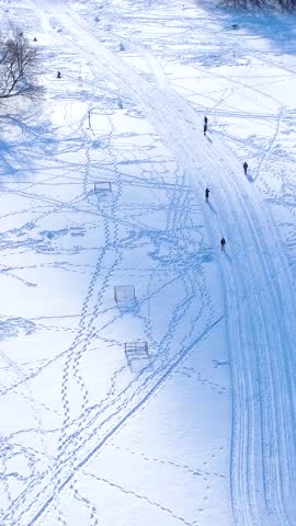 Snowy Landscape Shows People Walking and Skiing on a Winter Day Near Trees and Open Space