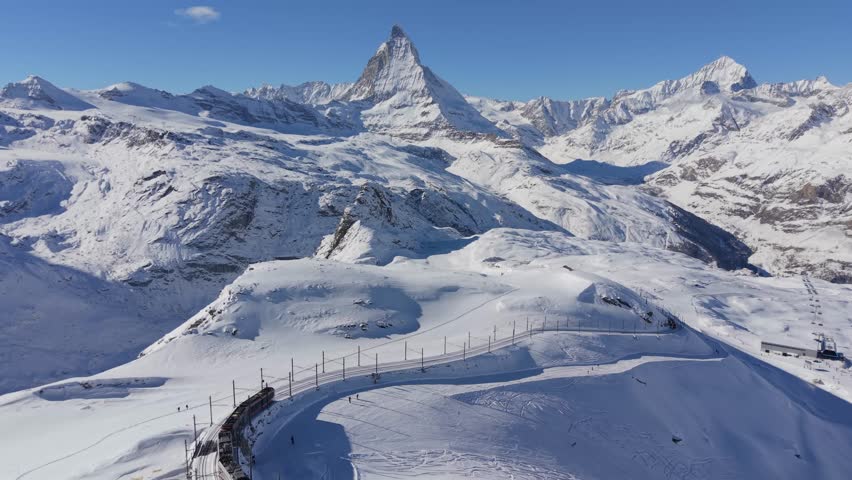 Gornergrat Railway Through the Winter Alps, Matterhorn and the Midday Alpine Glow. Zermatt, Switzerland -The train of Gonergratbahn running to the Gornergrat station 
