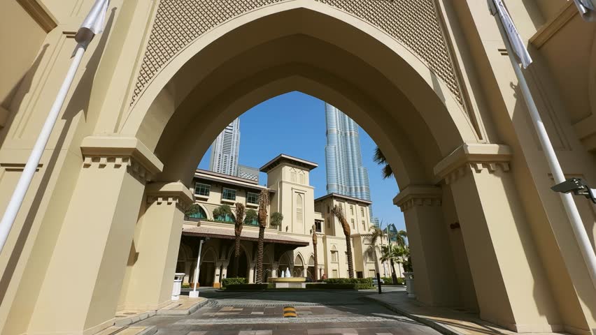 Establishing shot of traditional arabian architecture framed by an elegant arch in downtown of Dubai, no logos