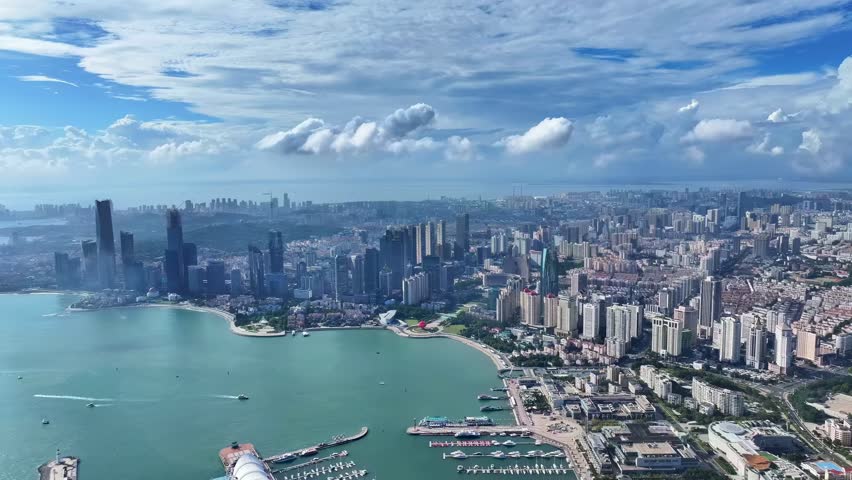 Aerial view of Chicago skyline with Lake Michigan, downtown skyscrapers, and turquoise waters under blue sky with white clouds.