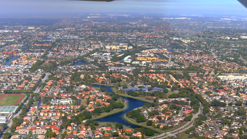 Suburban Miami with houses roads and river seen from small aircraft aerial view 