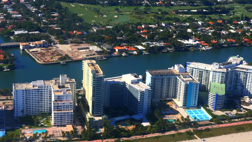 Tropical coastal city with golf course waterfront homes and highrises aerial 
