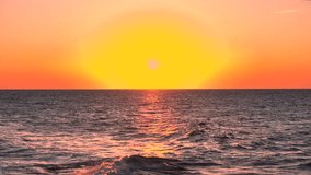 AERIAL, LENS FLARE: Golden setting sun is low over the Mediterranean horizon as small waves roll against a rugged rocky shoreline, catching warm reflections on sea surface. Peaceful scenery at Sicily. - Powered by Shutterstock - Get 15% off with code: PIKWIZARD15