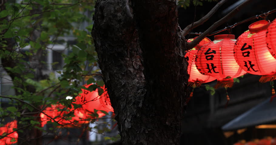 The red lanterns hanging along Dihua Street in Taipei emit a warm glow, creating a strong atmosphere of traditional festival and historical beauty.