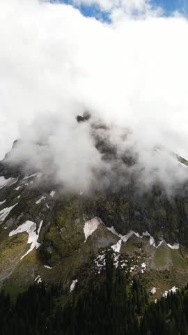 Fronalpstock Alps rocky mountain landscape partially obscured by clouds mist Switzerland aerial