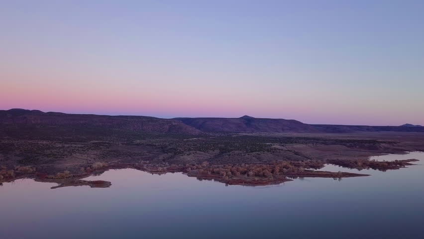 Colorful reflections in lake at sunset, Indian Reservation and Pueblo Land, Cochiti Lake, New Mexico Southwest, Golden Hour Sky, Drone Aerial, 4K
