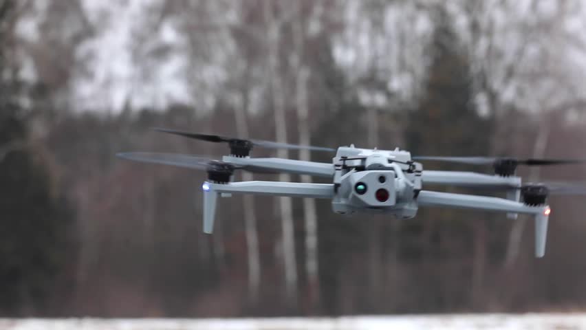 Professional Drone Flying in Snowy Field Near Forest.