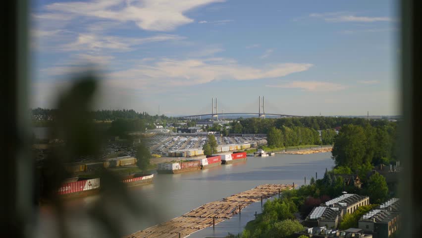 Elevated penthouse view overlooking the Fraser River, shipping channel, and SkyBridge in New Westminster, British Columbia on a calm, clear day